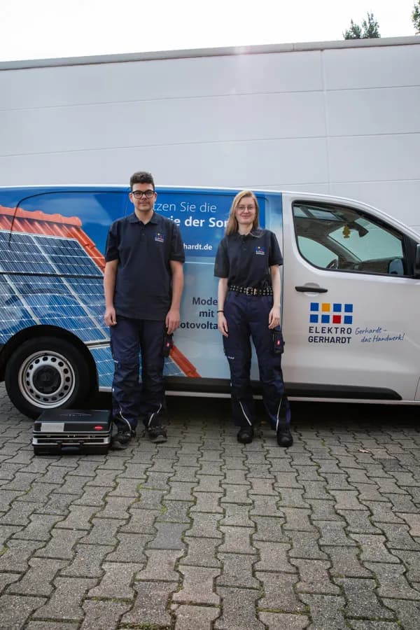 Zwei Auszubildende vor einem Servicefahrzeug von Elektro Gerhardt