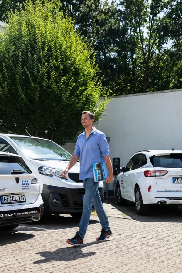 Mitarbeiter zwischen den Servicefahrzeugen auf dem Betriebshof