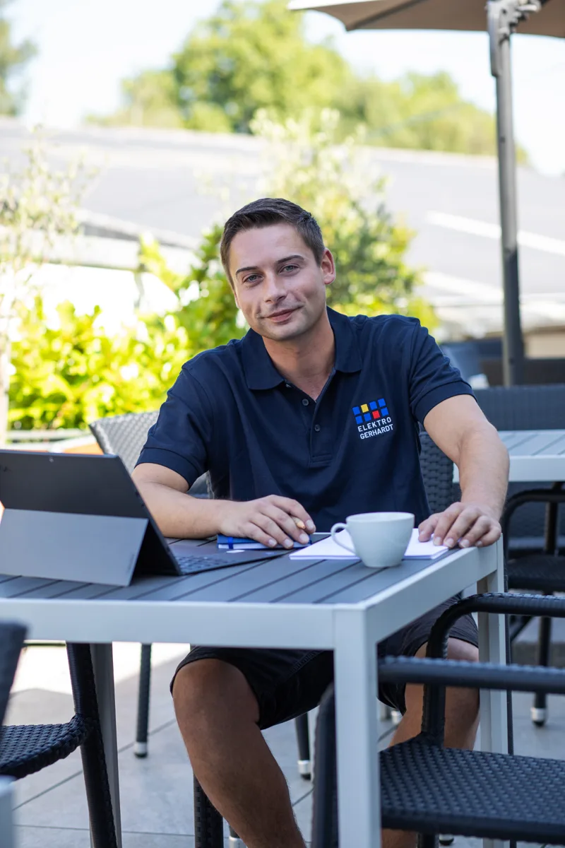 Mitarbeiter von Elektro Gerhardt mit Tablet und Notizen auf der Betriebsterrasse